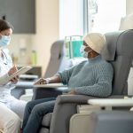 A professional medical setting showing a healthcare provider consulting with a patient undergoing chemotherapy, emphasizing compassionate and supportive care.