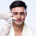 Medical professional marking a man's face with a pen before a facial plastic surgery procedure