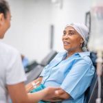 A healthcare professional providing supportive care to a patient receiving chemotherapy treatment.