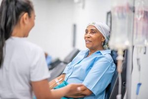A healthcare professional providing supportive care to a patient receiving chemotherapy treatment.