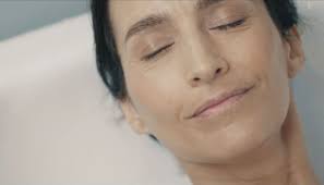 A woman resting with her eyes closed, appearing peaceful during her post-chemotherapy retreat.